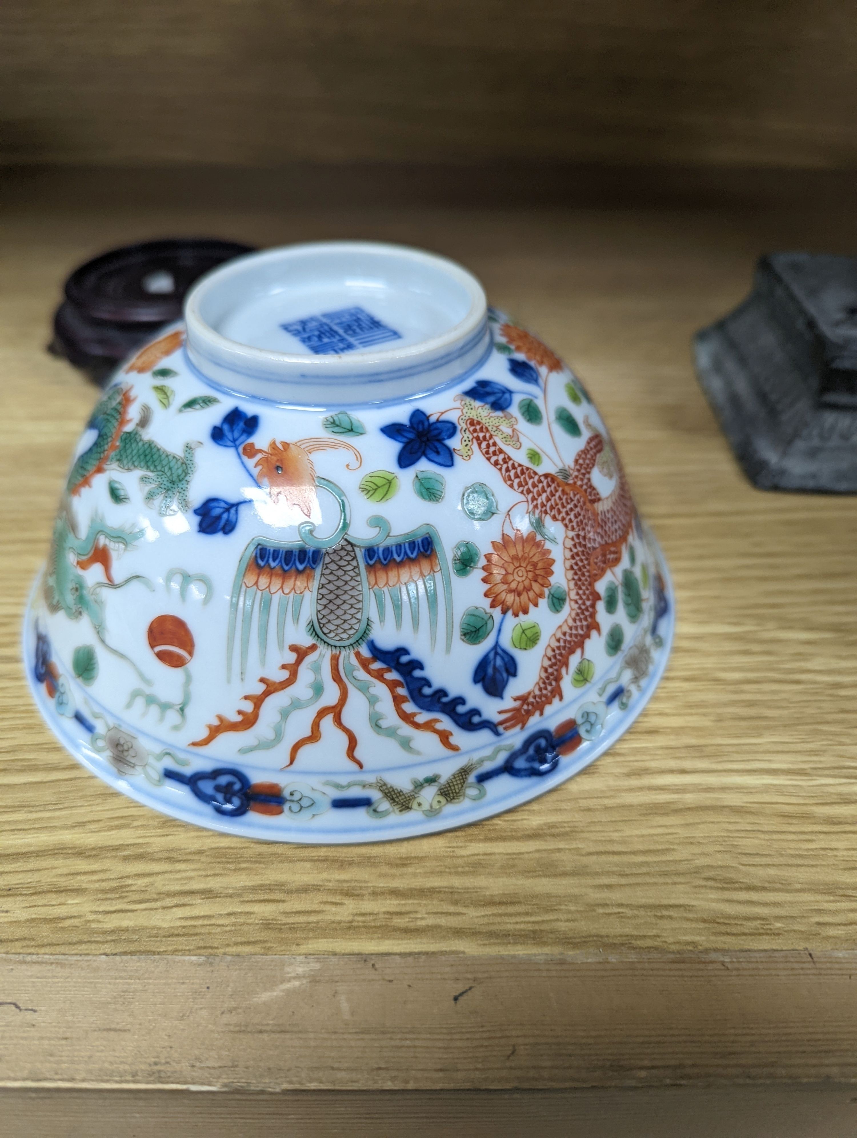 A Wucai bowl, dragon and flamingo pearl decoration, Jiaqing mark, on wood stand. 16cm diameter
